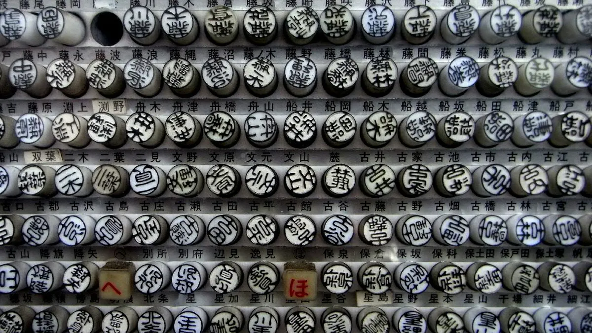 Rack of ready-made name seals (三文判) sorted by family name in a Japanese shop