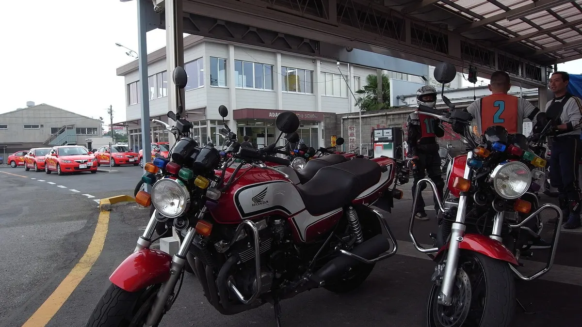 Training motorcycles lined up under a canopy at a driving school in Adachi, Tokyo